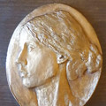 Portret pisarki”; brąz patynowany, drewno; wymiary: 16x19 cm
